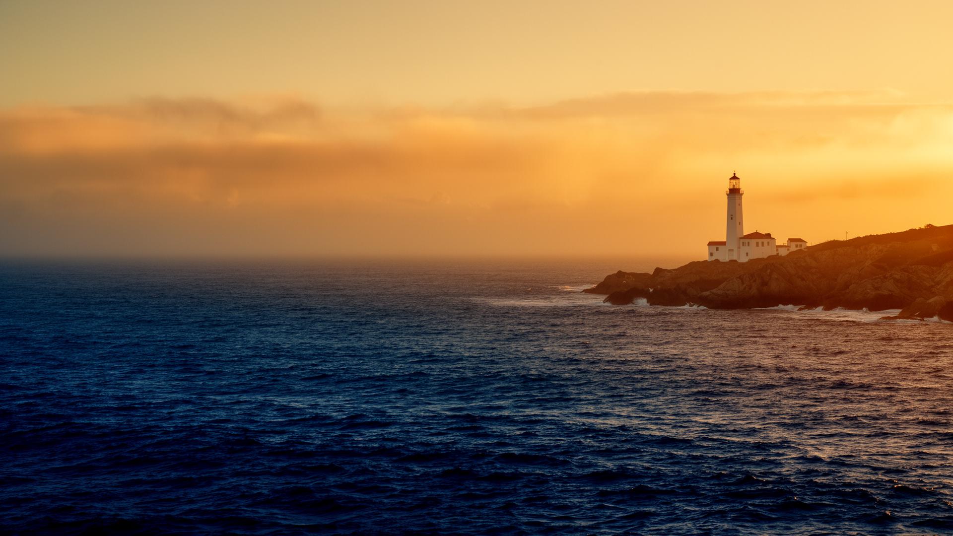 Leuchtturm an einer ruhigen Küste bei Sonnenuntergang